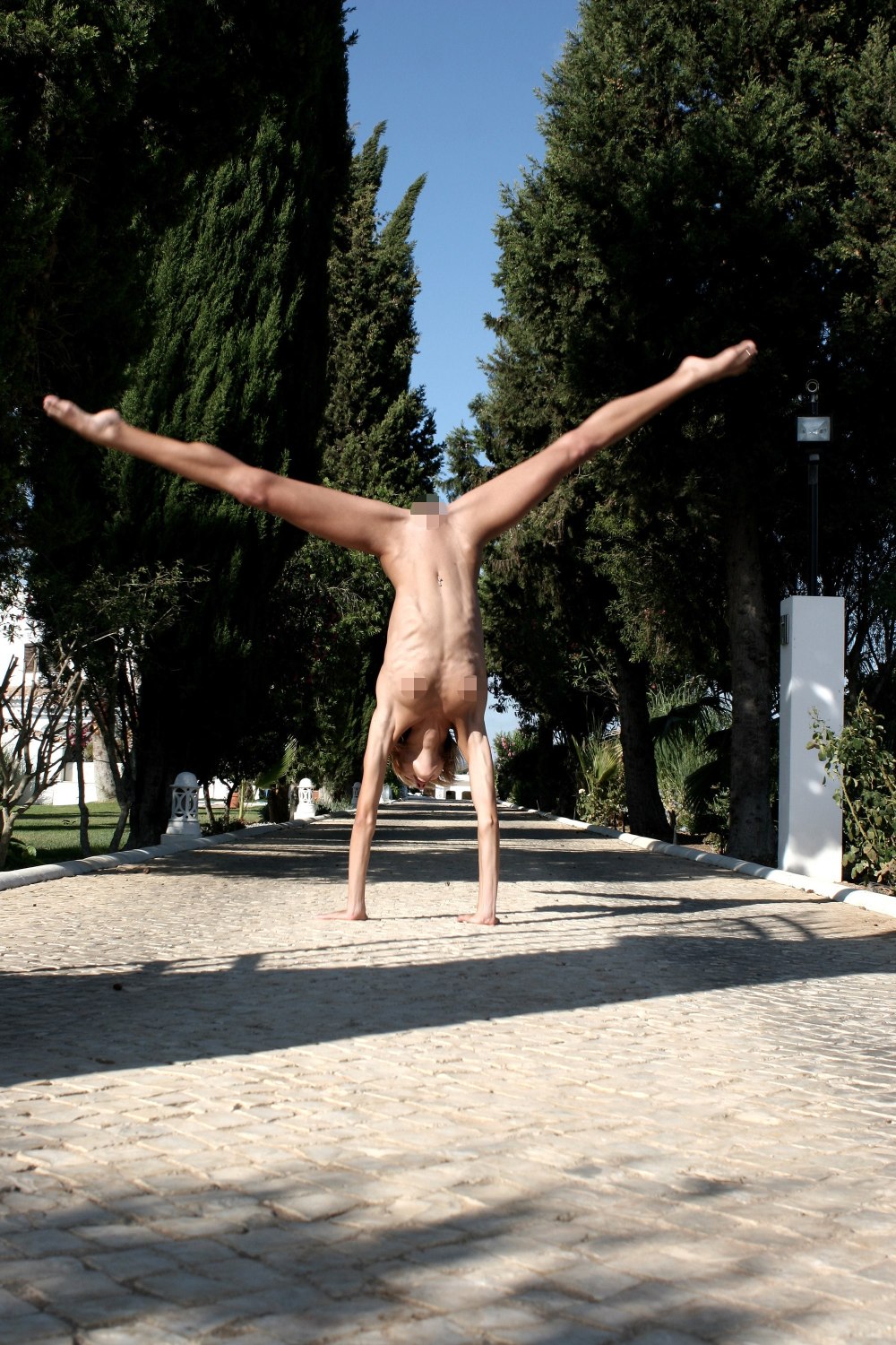 Girl on the horizontal bar upside down nude